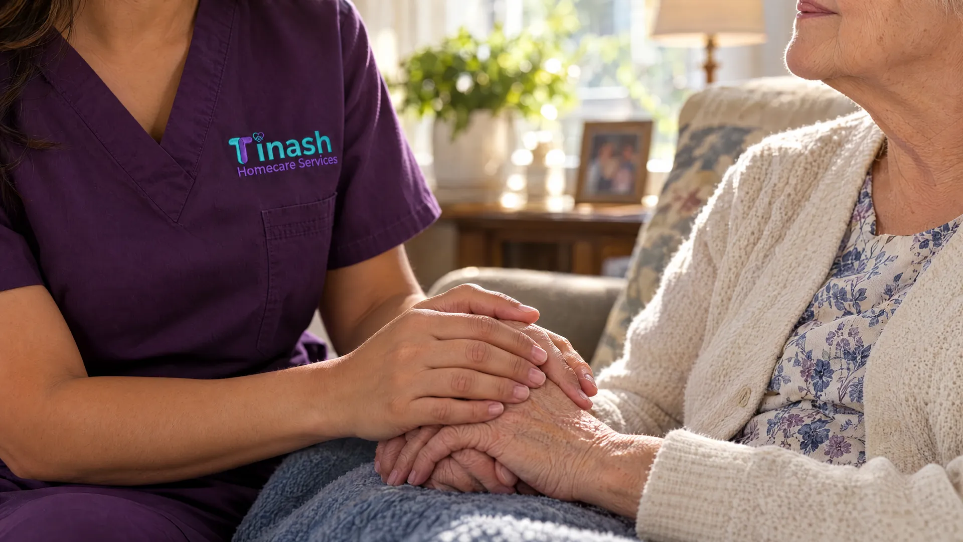 A Tinash caregiver gently holding an older woman's hands